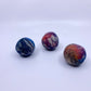 Three multicoloured felt balls on a white background