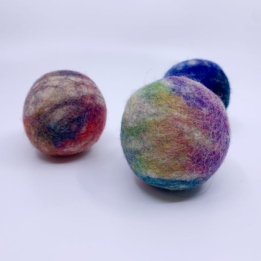 Three multicolored felted balls on a white background