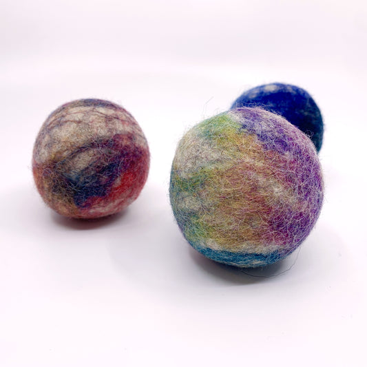 Three multicolored felted balls on a white background