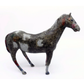 A small decorative horse figurine with a distressed, textured finish in dark gray, black, and white, accented with red and blue paint on its legs and face, set against a plain white background.