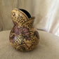 Decorative gourd with floral patterns on a beige surface