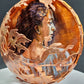Decorative copper bowl with leaf patterns on a dark background