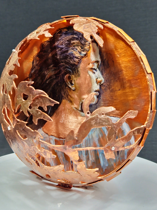 Decorative copper bowl with leaf patterns on a dark background