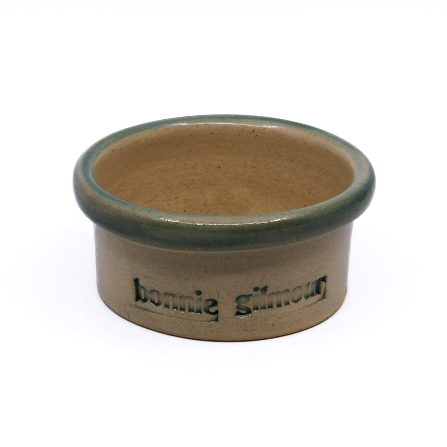 Clay ramekin with green rim and "MEACHAM" on one side and "bonnie gilmour" on the other 