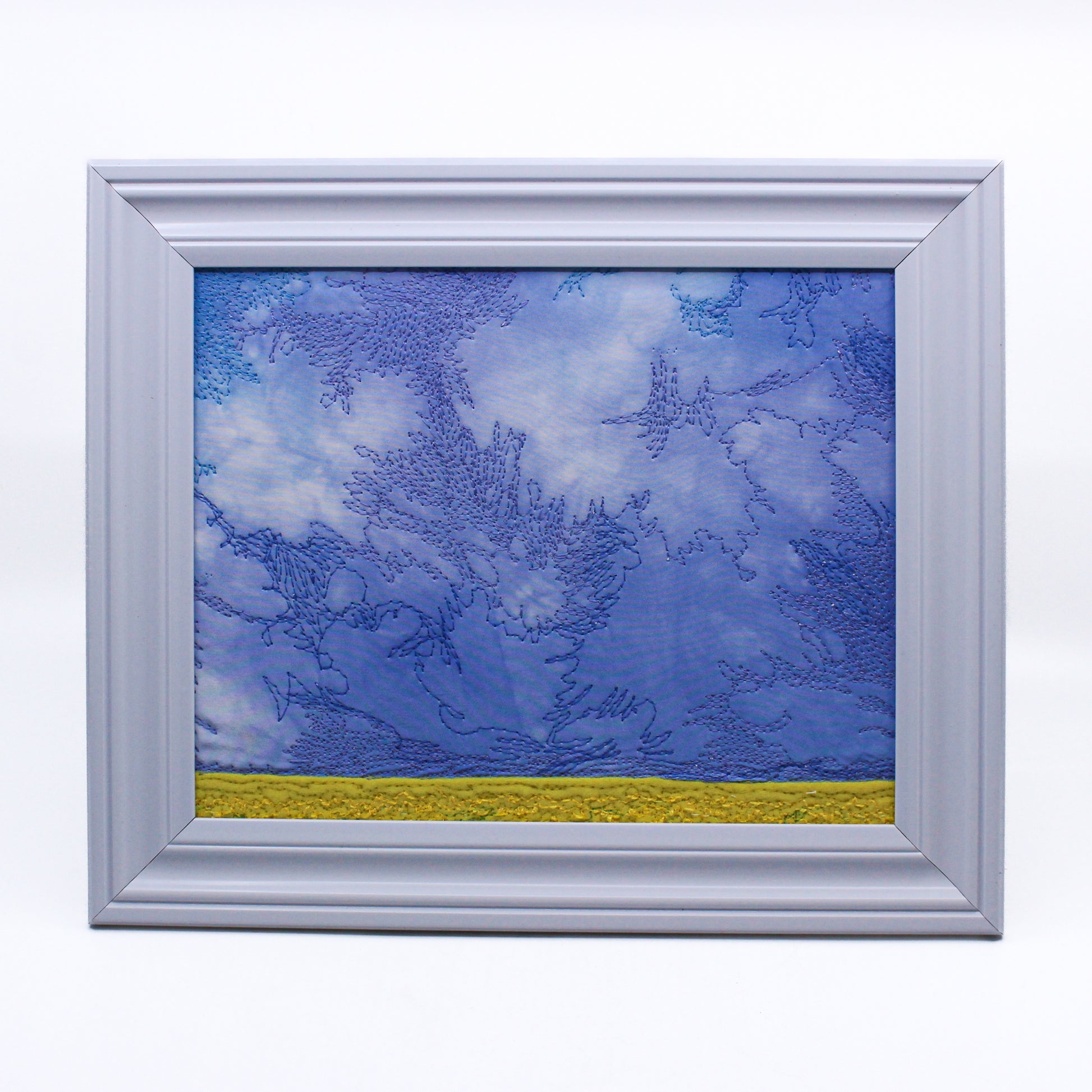 Thread painting of blue sky over a yellow field 