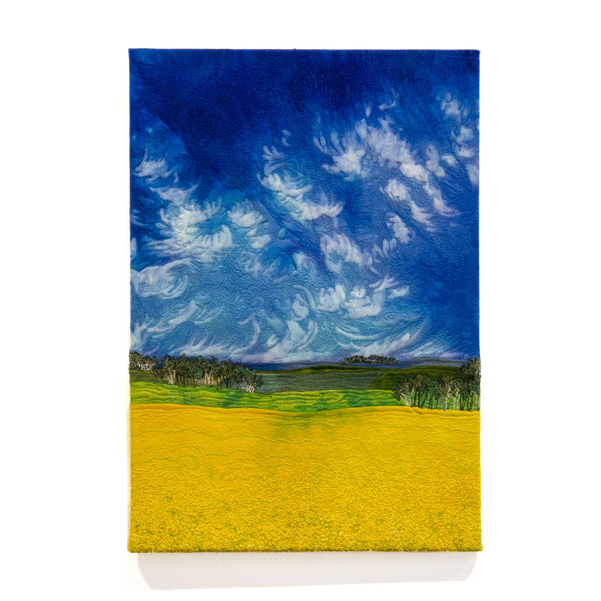Embroidered painting of a storm sky and canola fields