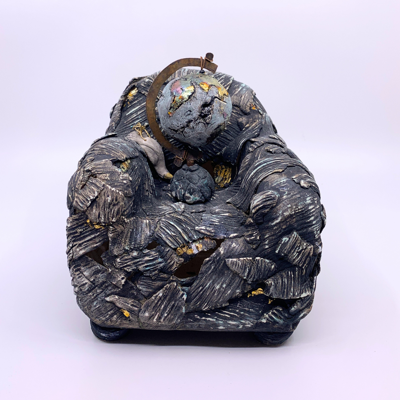 sculpture of couch with earth and dead bird 