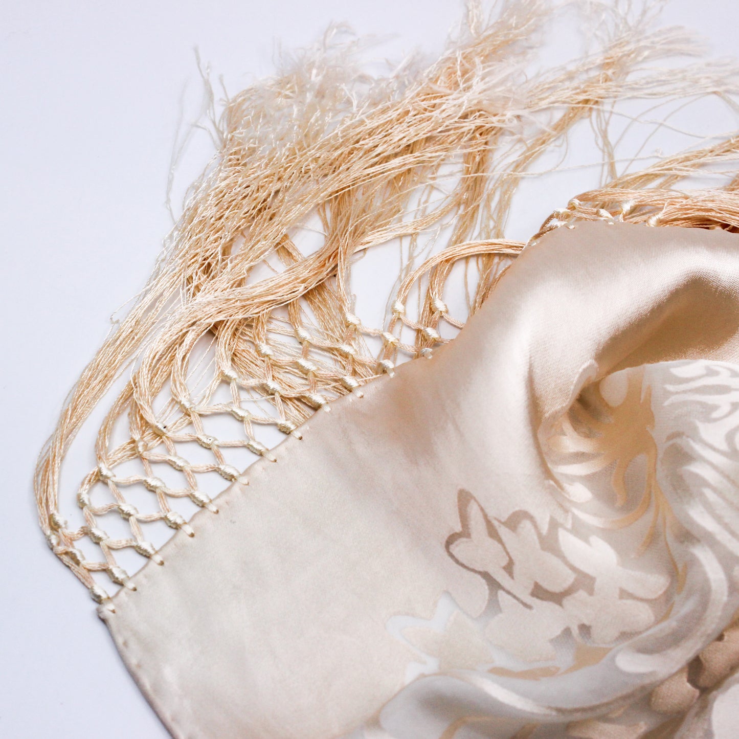 detail of cream scarf with long tassels 