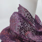 Purple patterned fabric draped over a mannequin on a white background