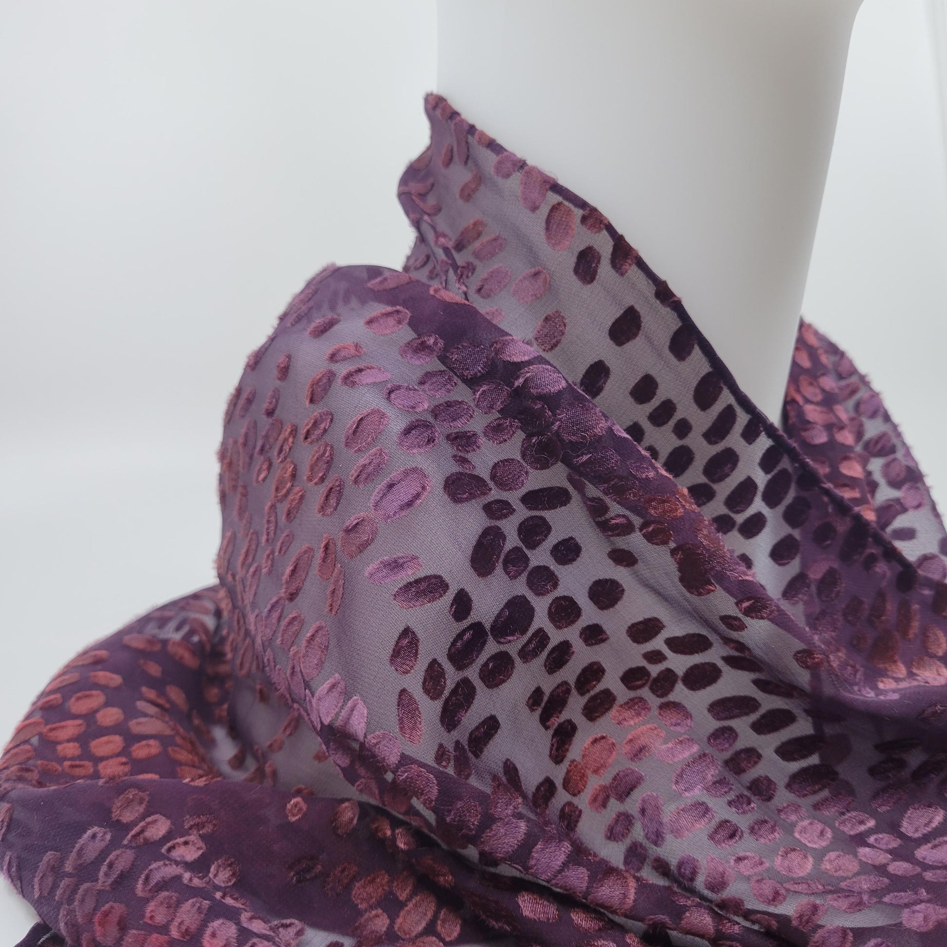 Purple patterned fabric draped over a mannequin on a white background