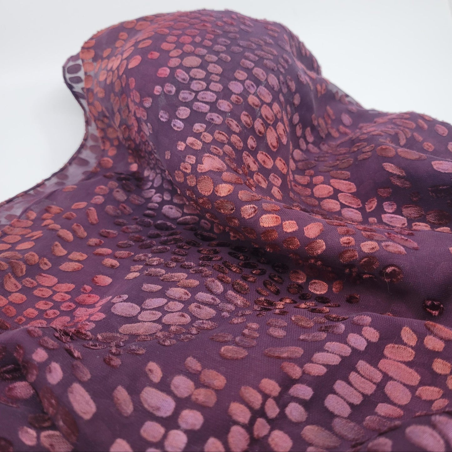 Purple fabric with a pattern of small, raised bumps on a white background