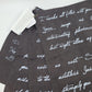 Textile with white cursive text on a dark fabric background