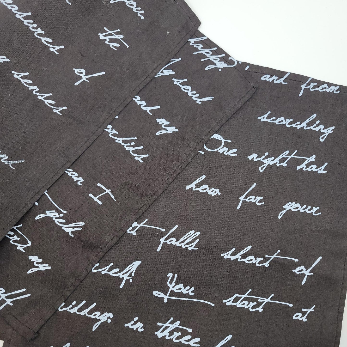 Dark fabric with white cursive text pattern