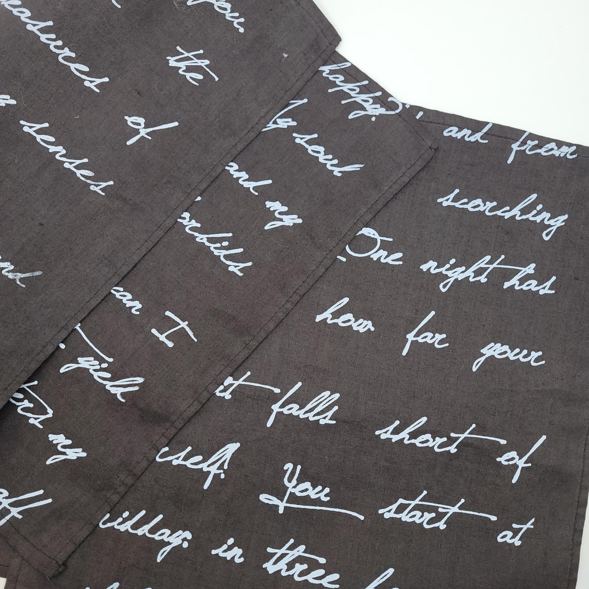 Dark fabric with white cursive text pattern