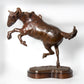 Bronze sculpture of a rearing horse on a white background