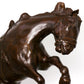 Bronze sculpture of a horse rearing on a white background
