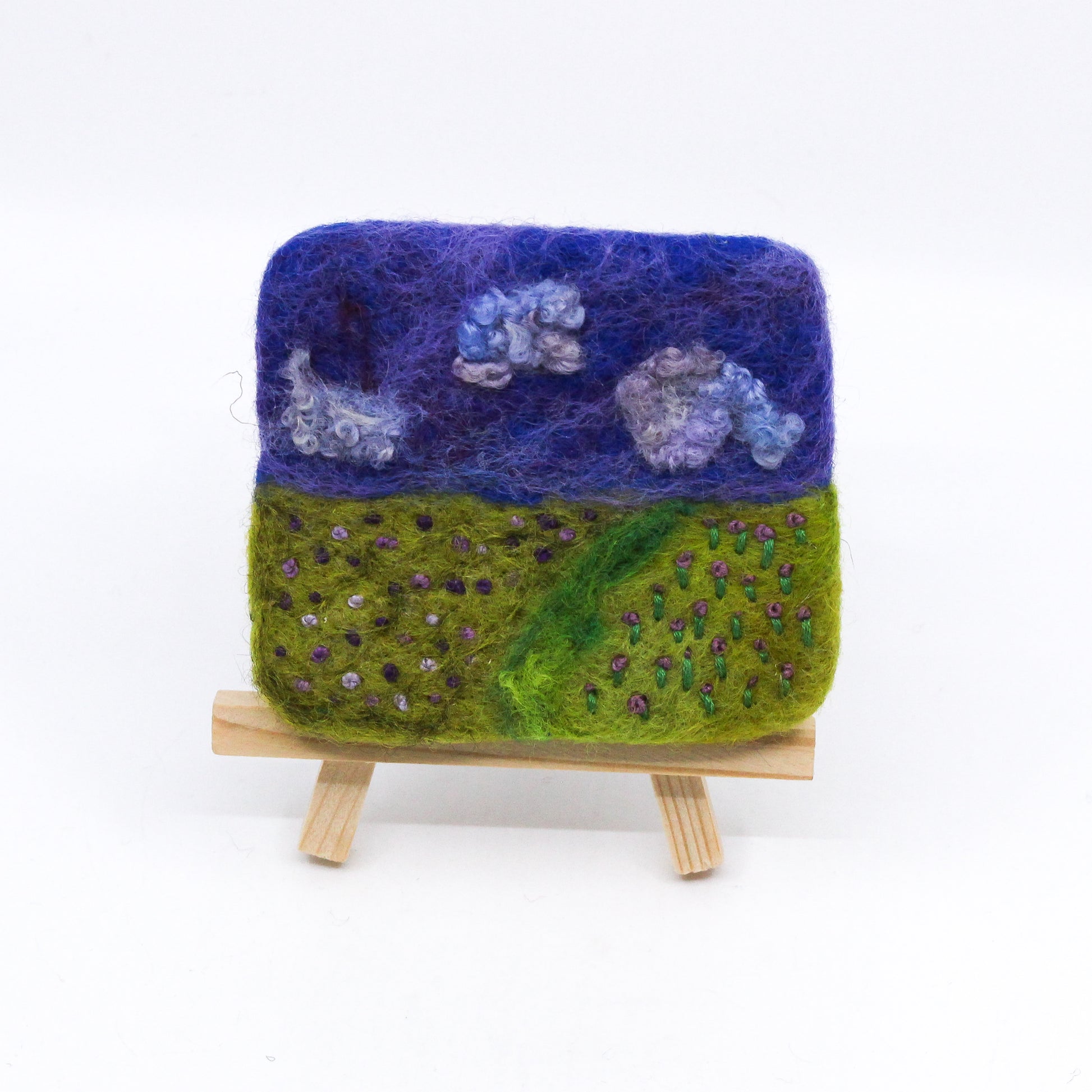 Felted landscape of purple flowers on wooden easel
