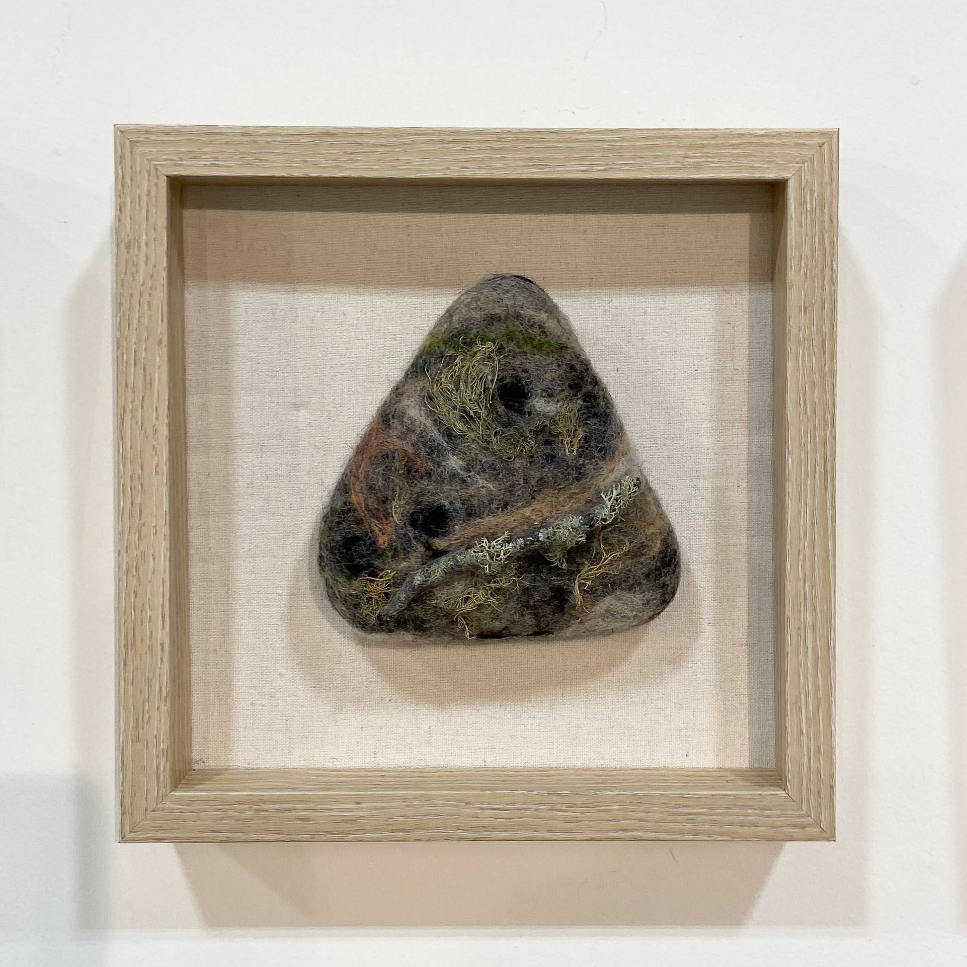 Triangular felted rock in frame
