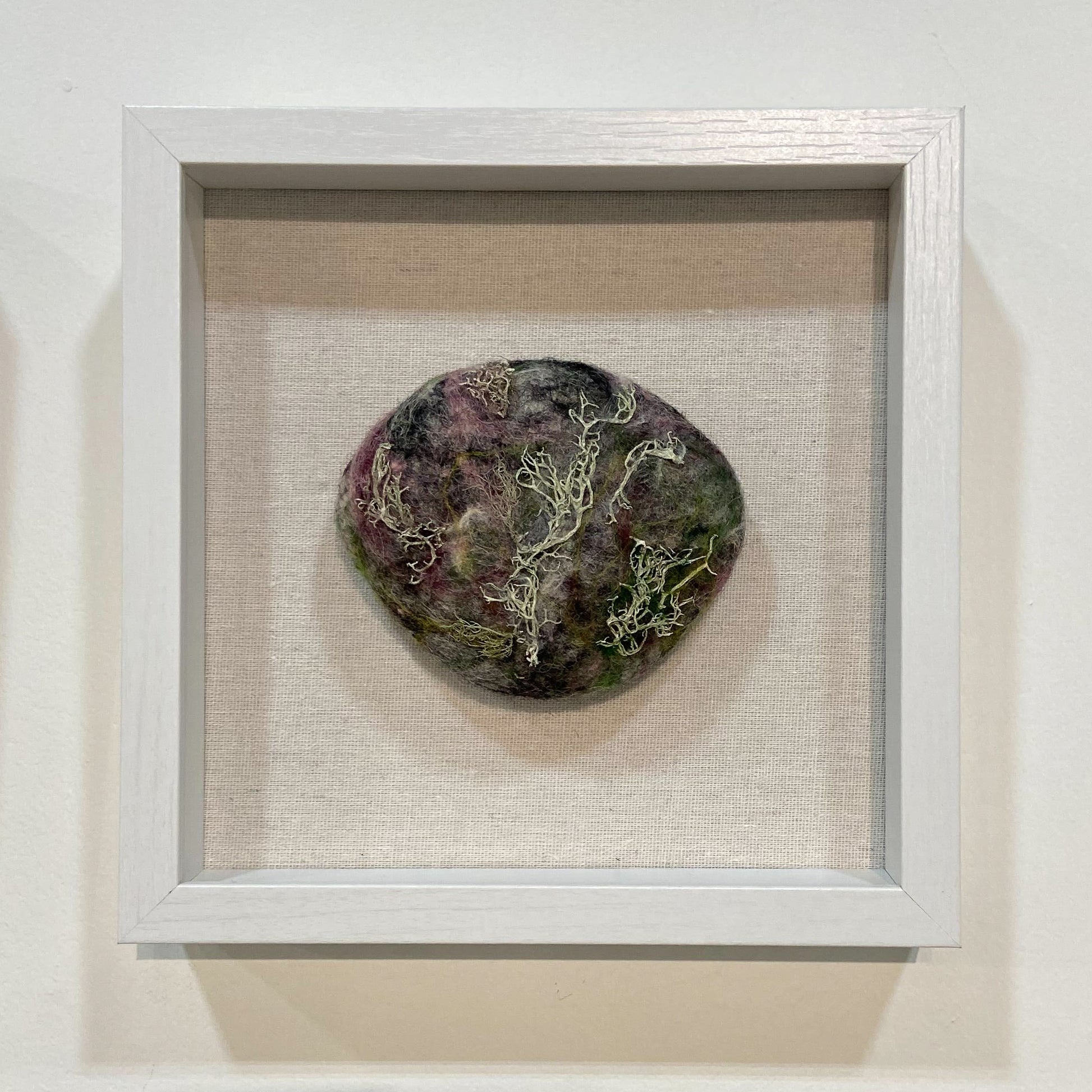 Circle felted rock in frame