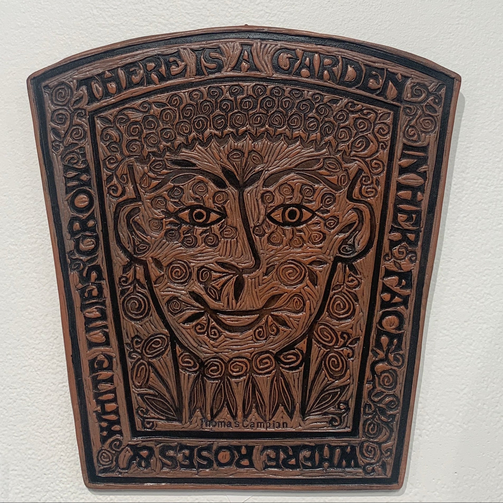 brown ceramic tile of a garden and face 