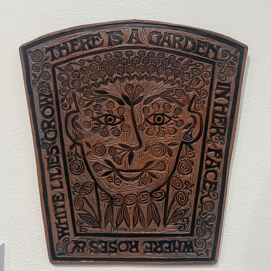 brown ceramic tile of a garden and face 