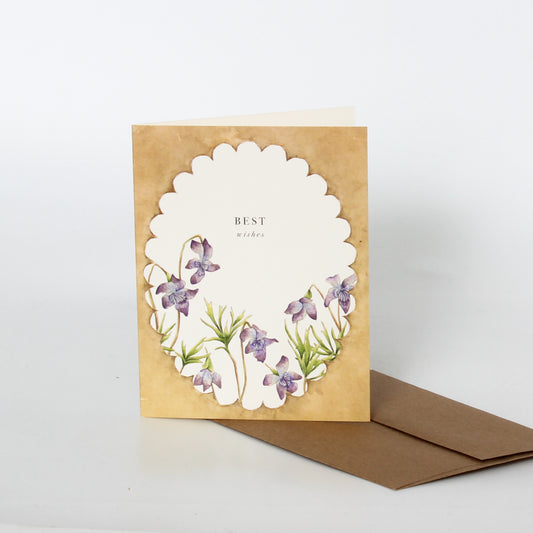 Greeting card with floral design and 'Best wishes' text on a brown envelope.