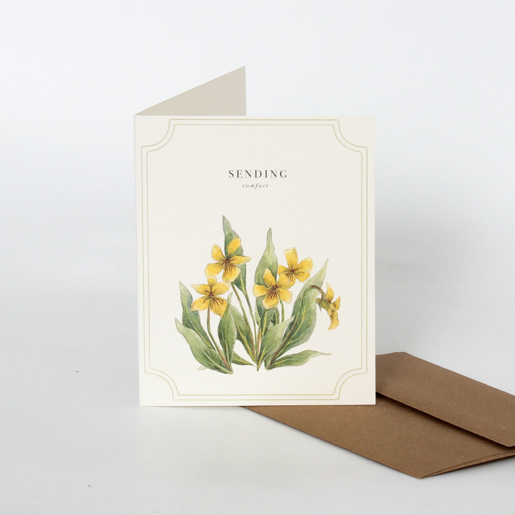 Off-white card with vintage floral design with words Sending Comfort" on it, with a brown envelope.