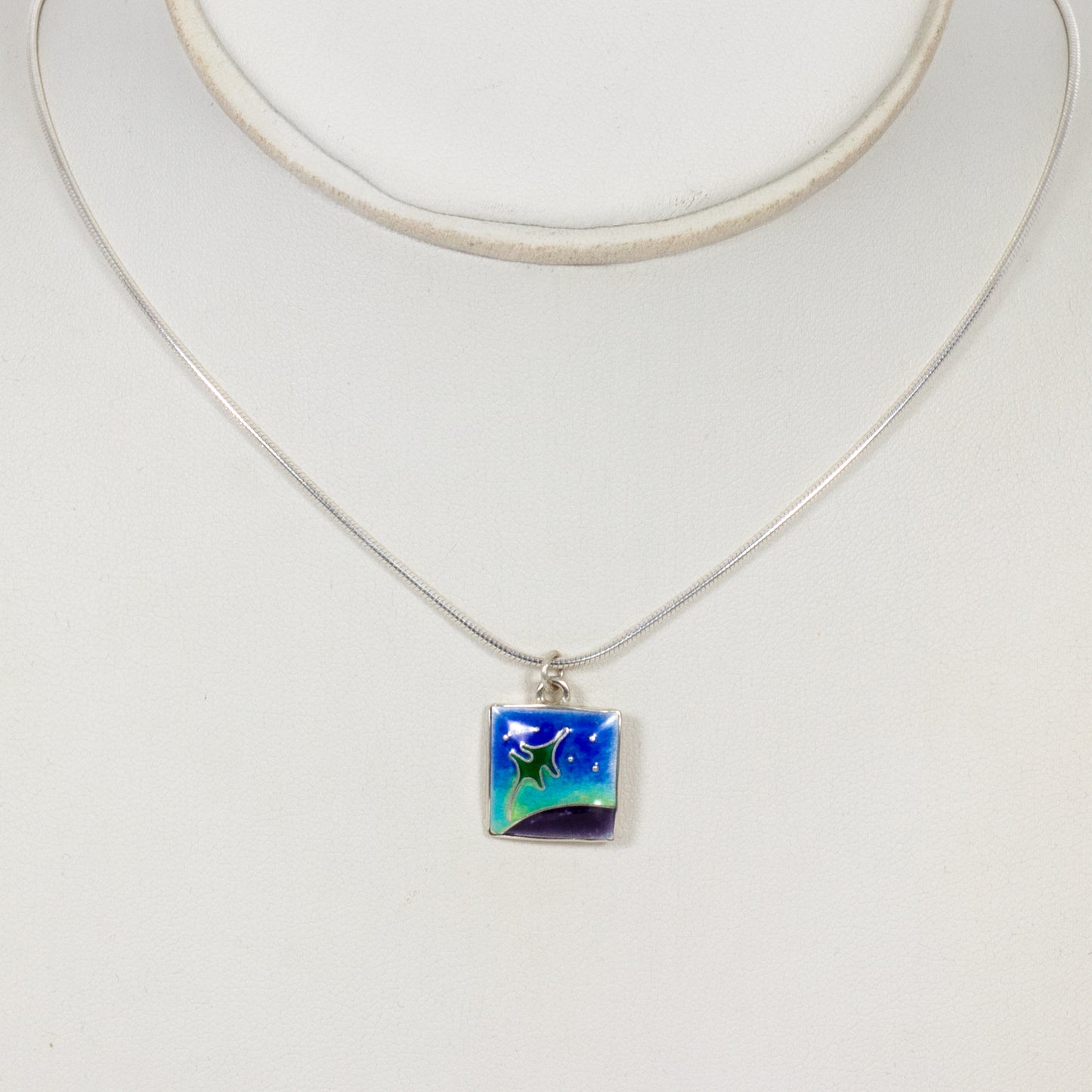 Necklace with a square pendant featuring a starry night design on a white background