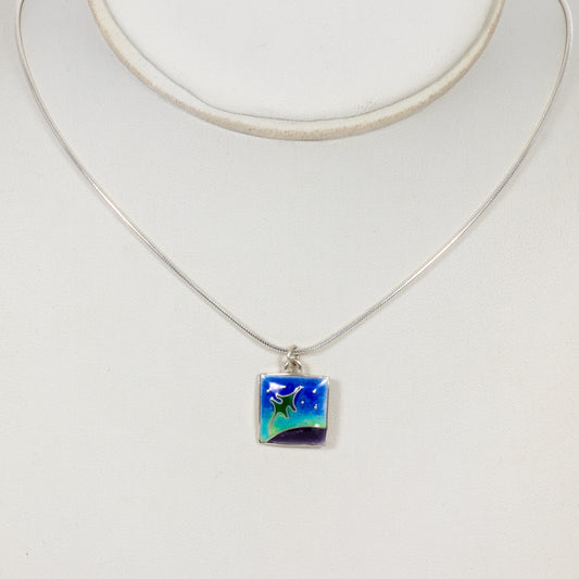 Necklace with a square pendant featuring a starry night design on a white background
