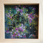 Framed artwork of embroidered purple flowers and green leaves