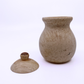 A light beige wood jar with a textured, natural marbled surface, shown alongside its matching lid on a clean white background.
