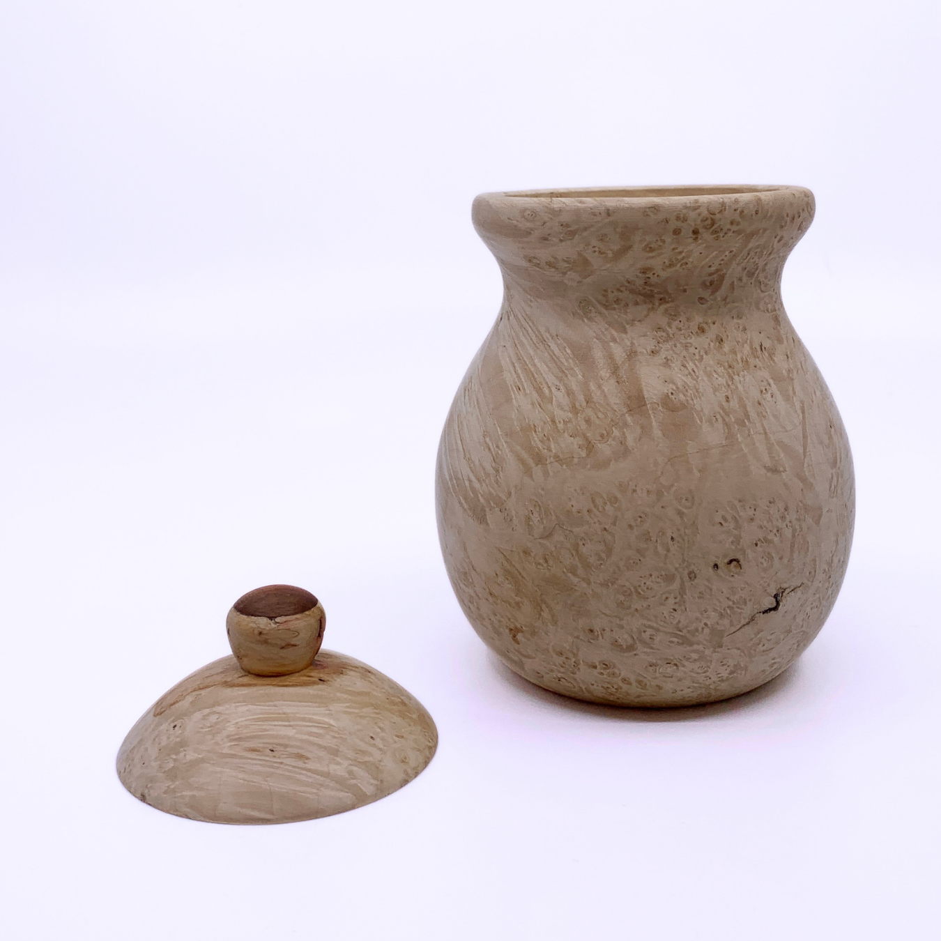 A light beige wood jar with a textured, natural marbled surface, shown alongside its matching lid on a clean white background.
