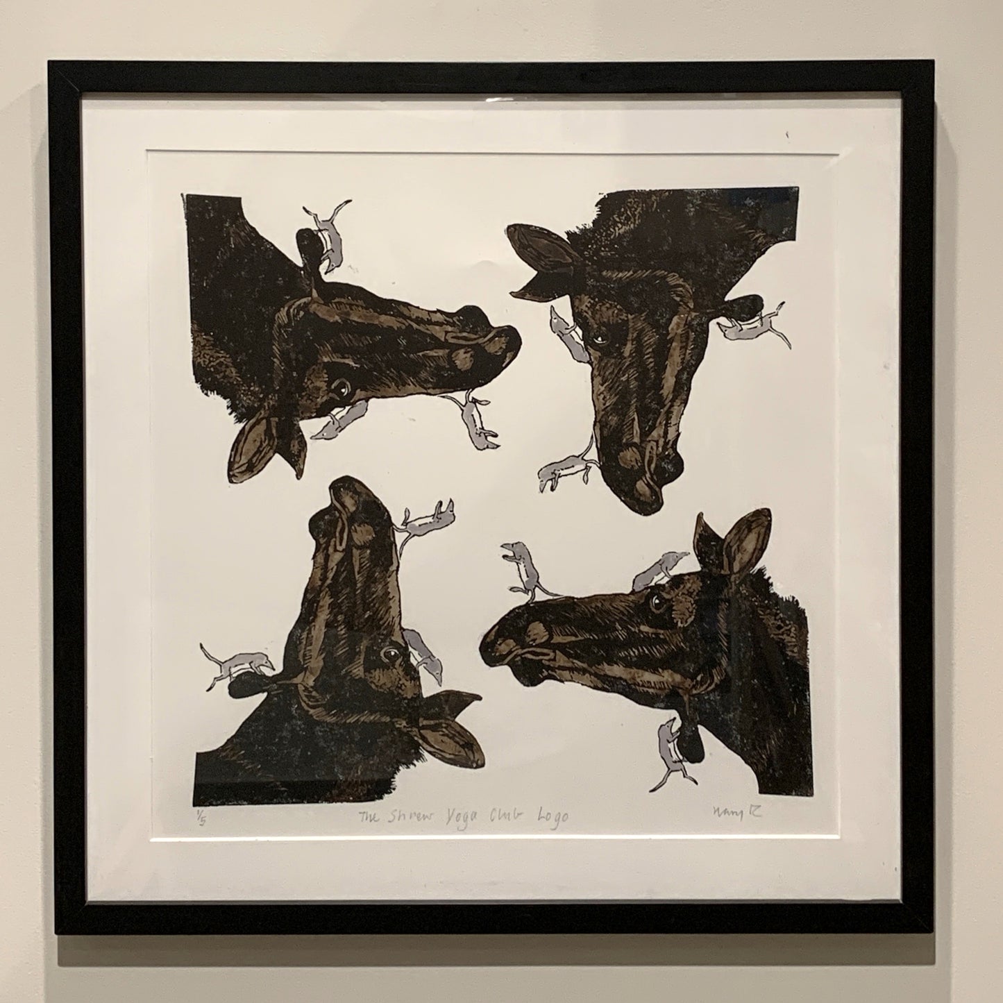 A square framed piece of art featuring four moose with several small shrews in a symmetrical pattern
