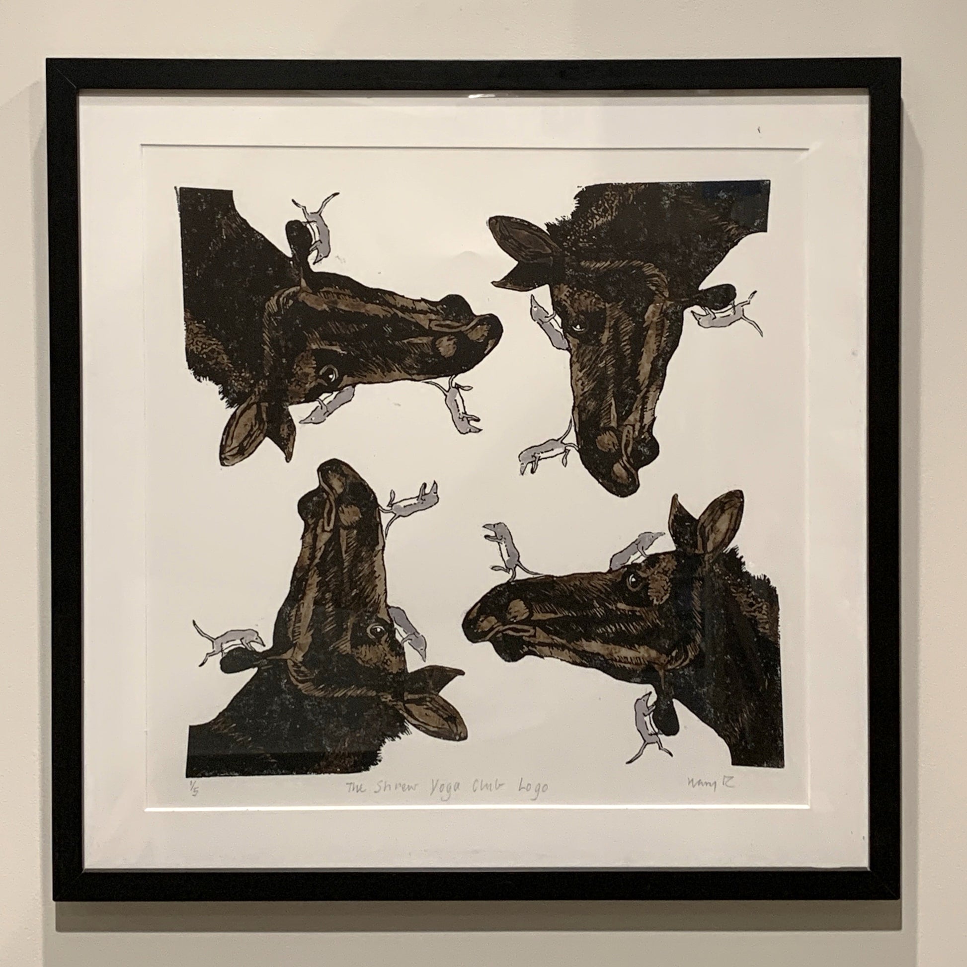 A square framed piece of art featuring four moose with several small shrews in a symmetrical pattern