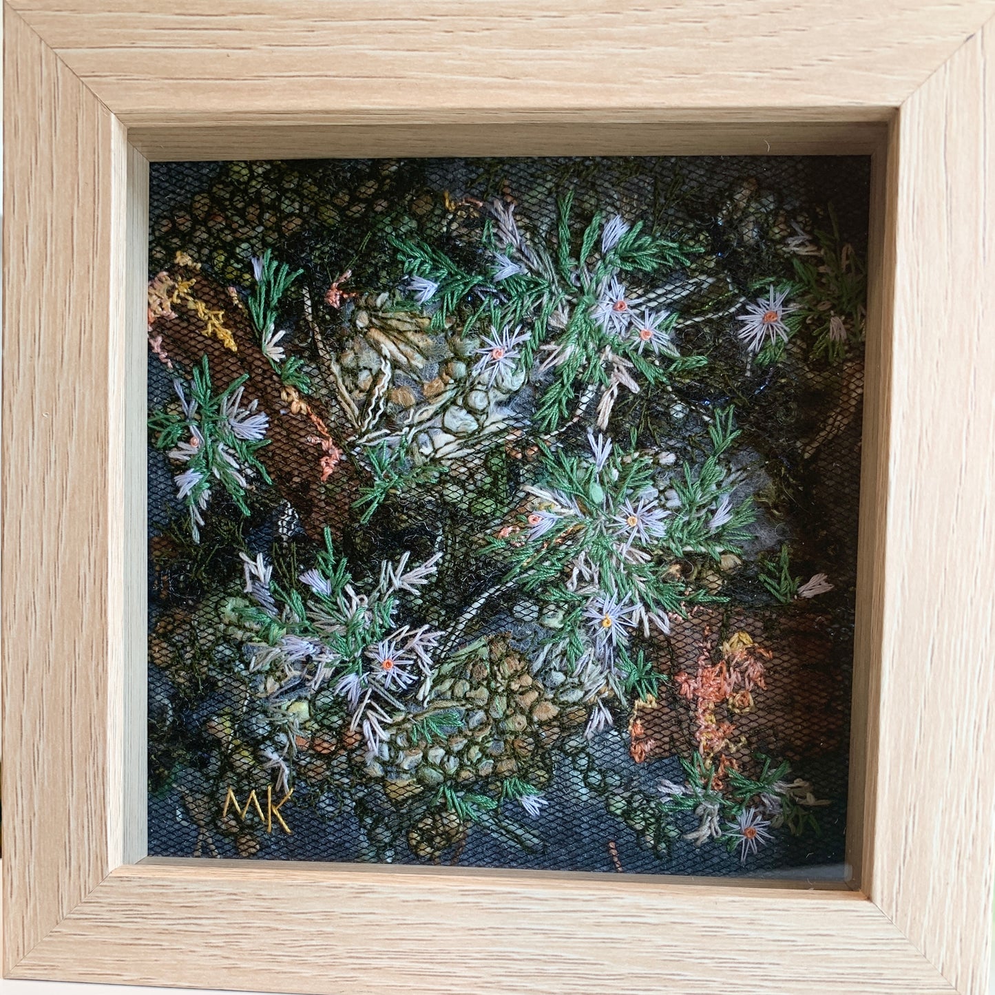 Framed embroidery of flowers with a wooden frame