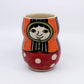 Dollie tumbler: orange and blue stripped hood, red dress with carved pokadots 