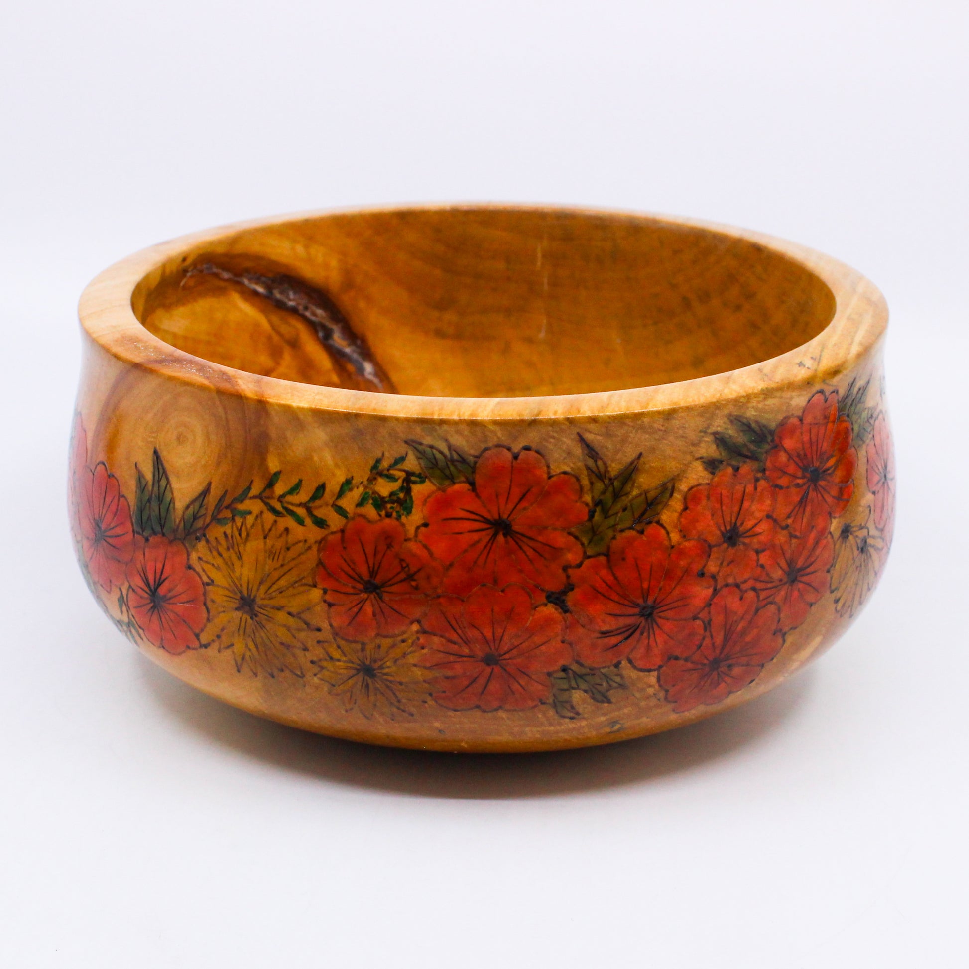 Wooden bowl with pattern of red flowers with green foliage and yellow flowers 