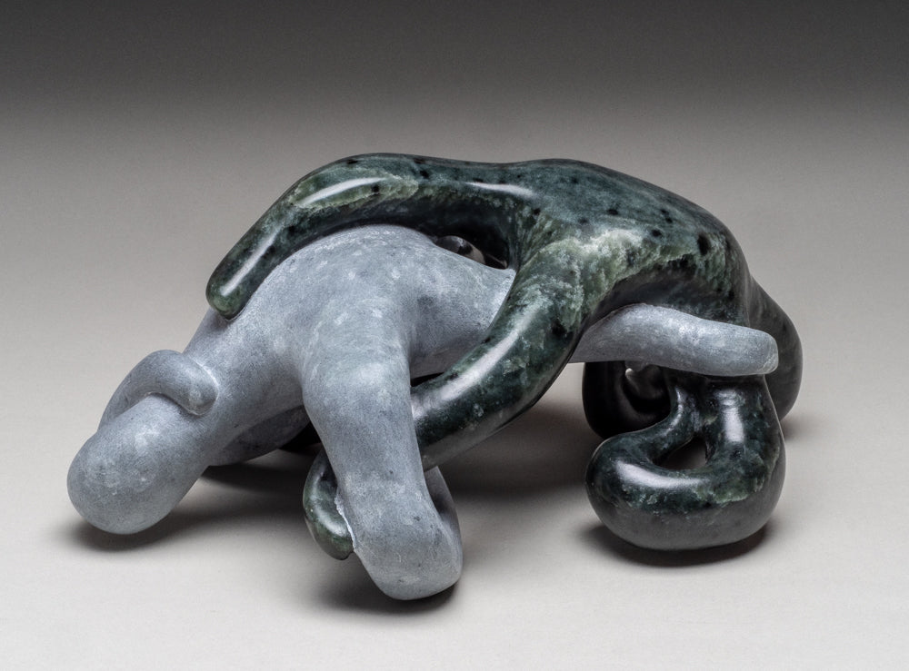 Two figures entwined together made of polished and unpolished soapstone