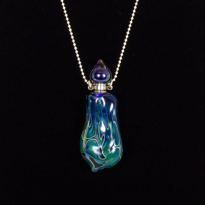 Glass pendant necklace with blue and green design on a black background