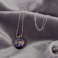 Necklace with a colorful pendant on a gray fabric background