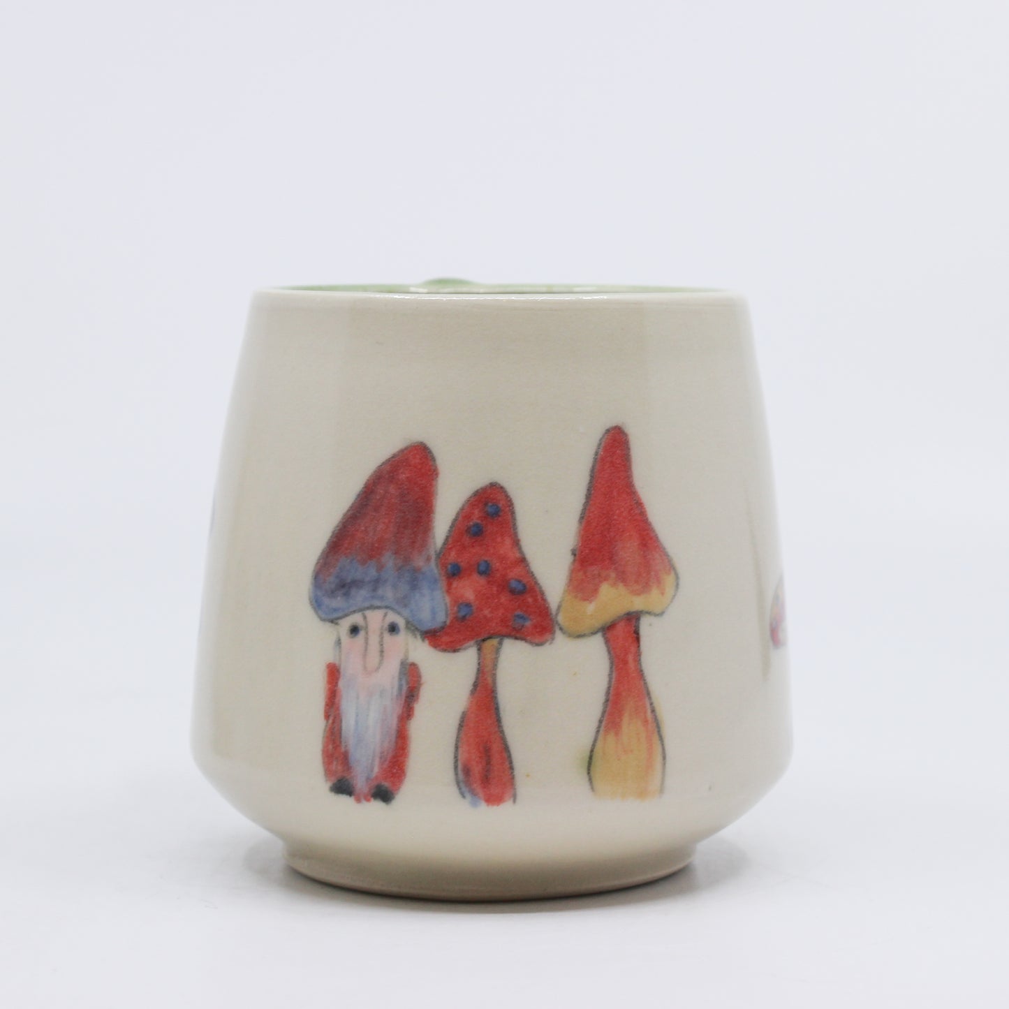 Hand painted gnome hiding with mushrooms on a mug