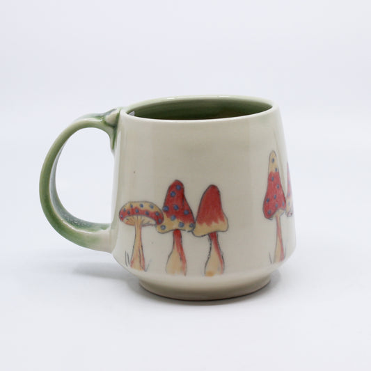 Mug with red mushrooms and a green handle