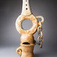 Clay sculpture with chain on a gray background