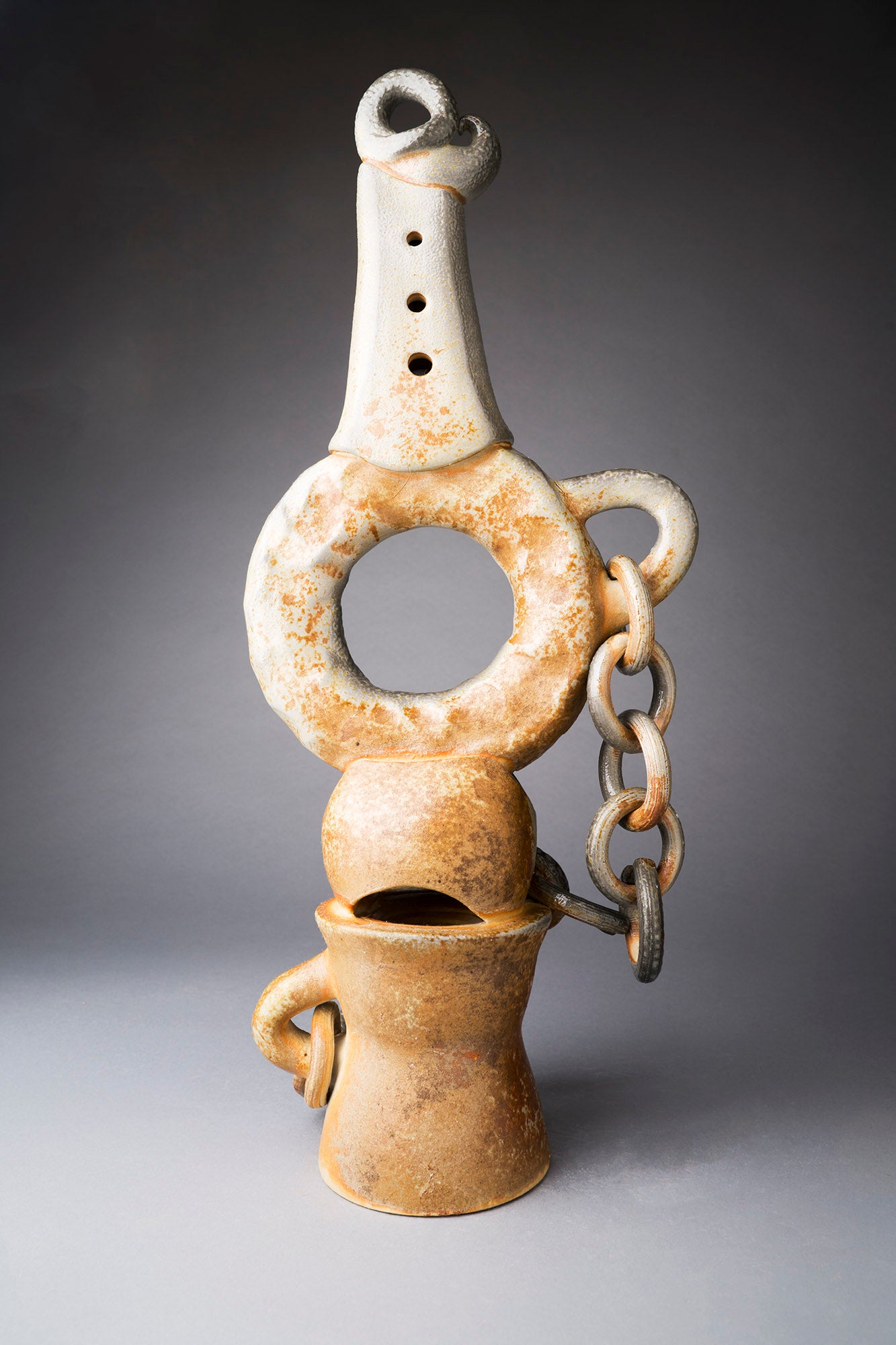 Clay sculpture with chain on a gray background