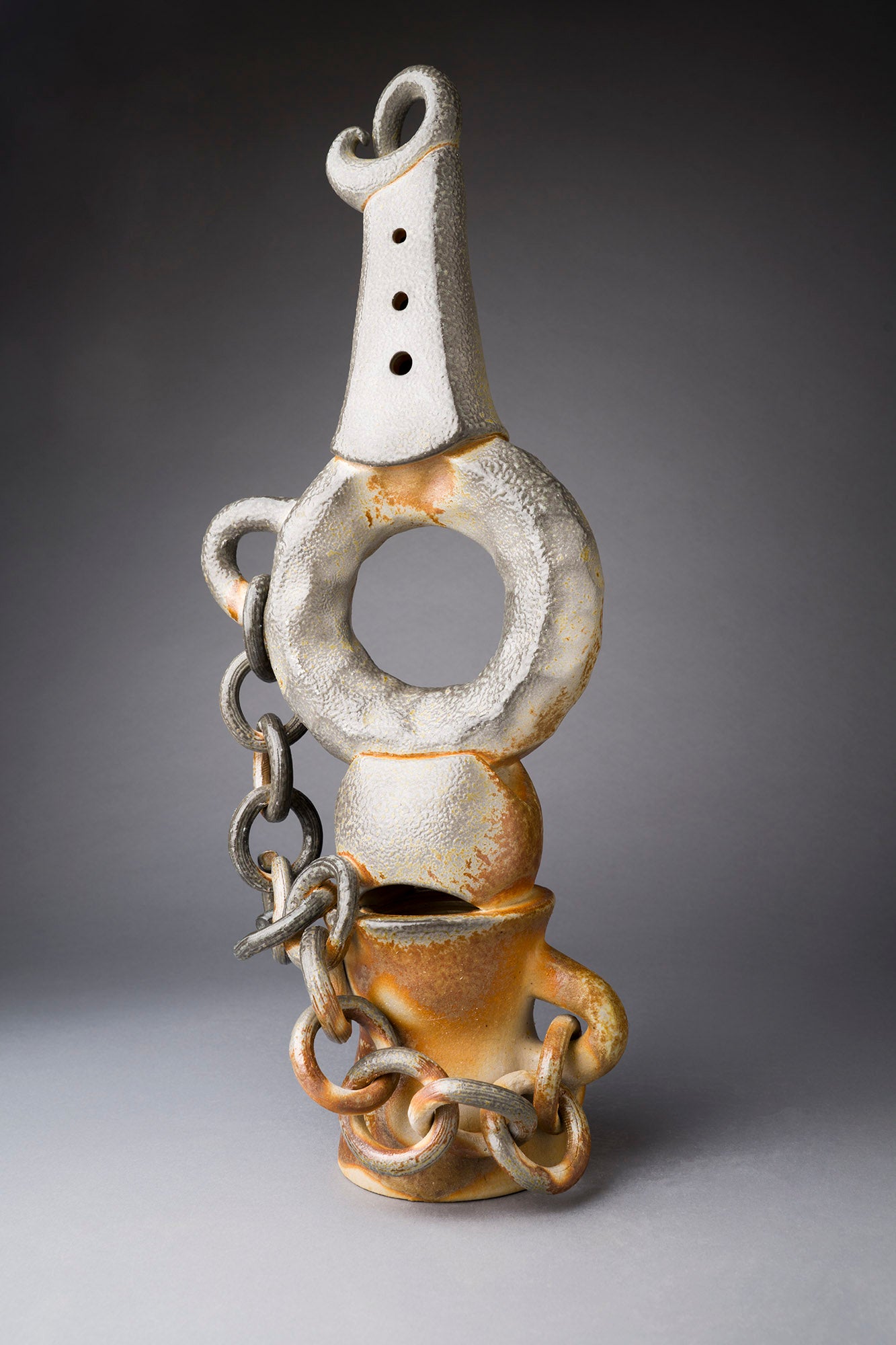 Clay sculpture with chain on a gray background