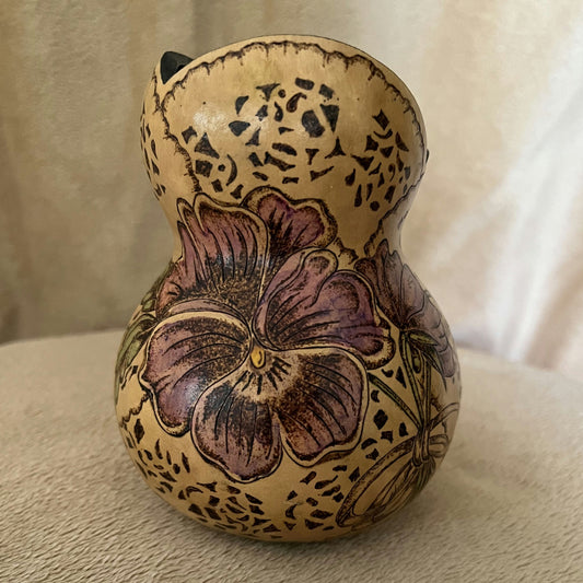 Decorative gourd with floral design on a beige surface