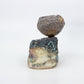 textured clay pot on top of rock