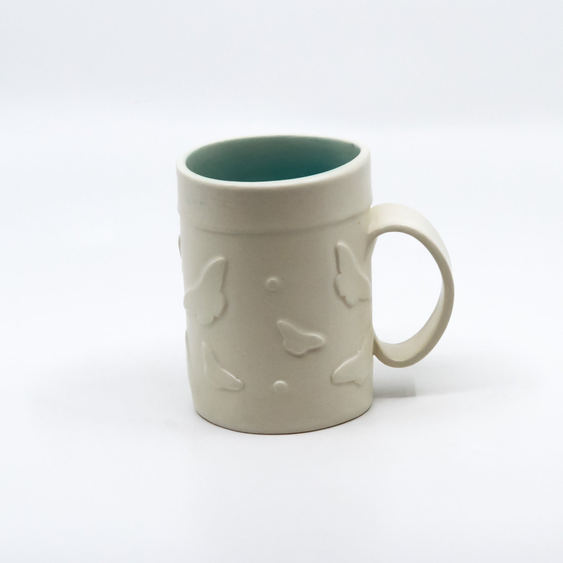 White mug with butterflies and turquoise inside