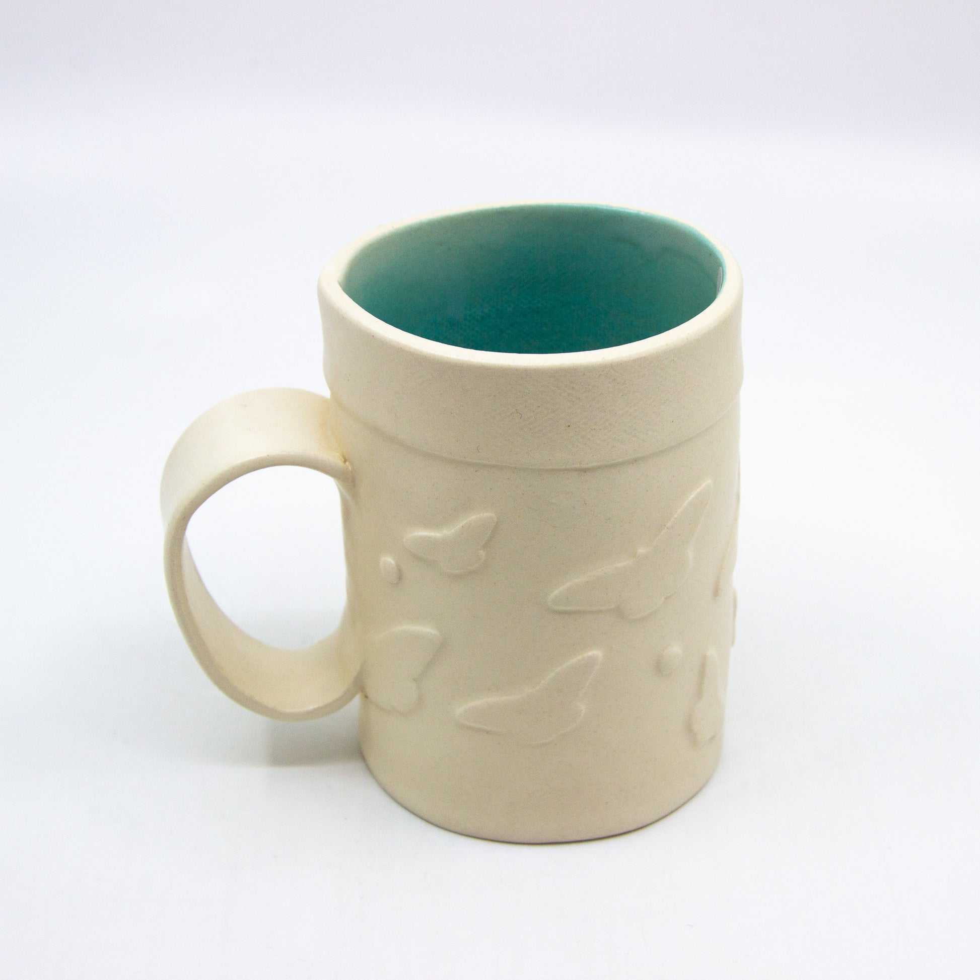 White mug with butterflies and turquoise inside