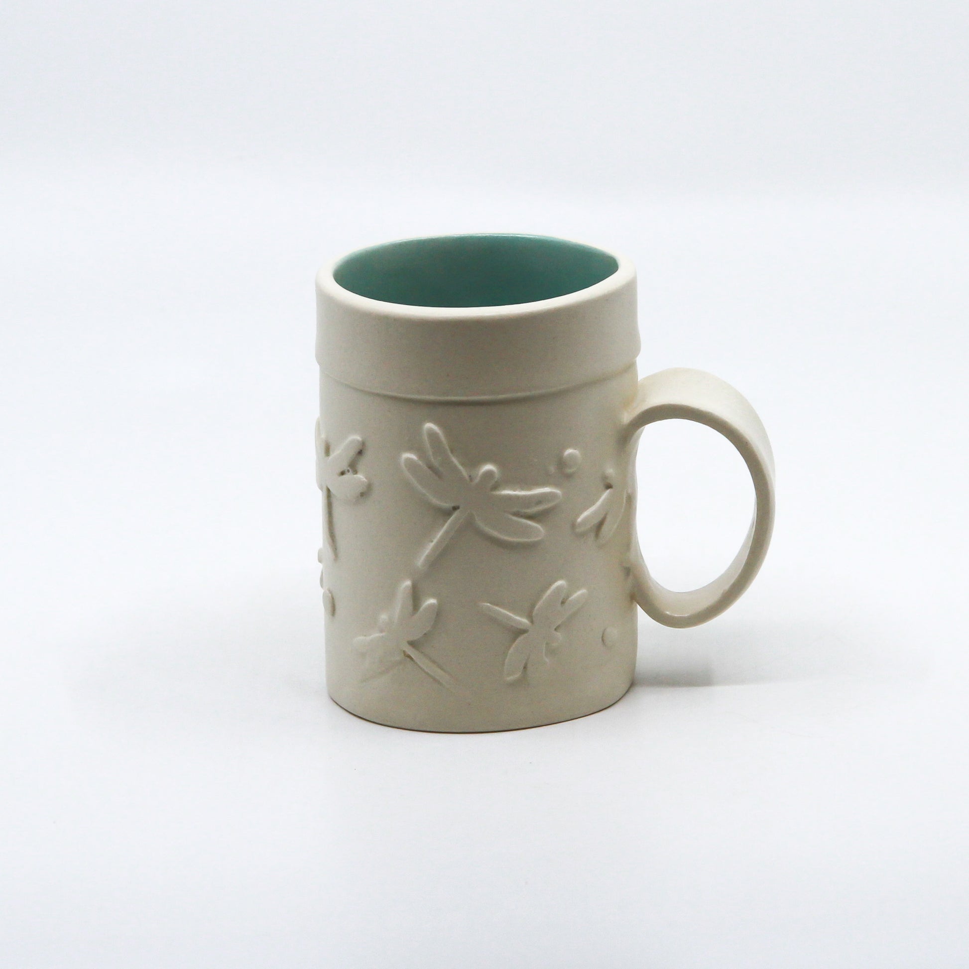 White mug with dragonflies and turquoise inside